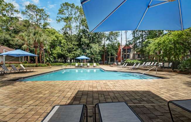 a swimming pool with chairs and umbrellas at the resort