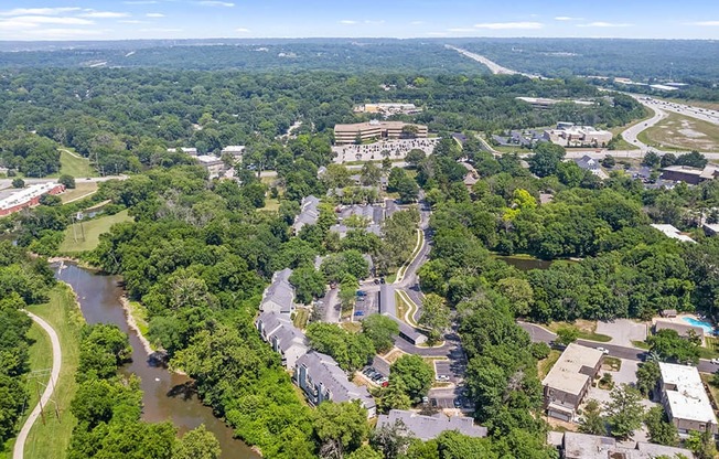 an aerial view of a city with a river and trees