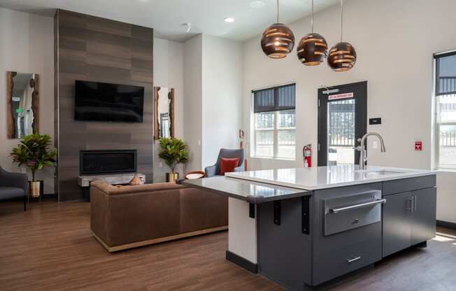 a kitchen with a large island in the middle of a room with a couch and a fireplace