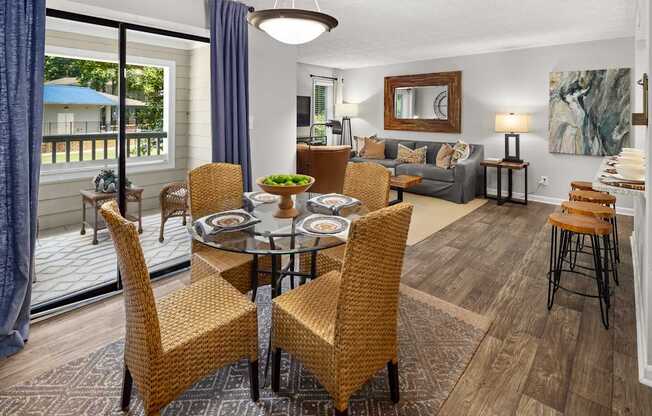 A dining room with a glass table surrounded by chairs.