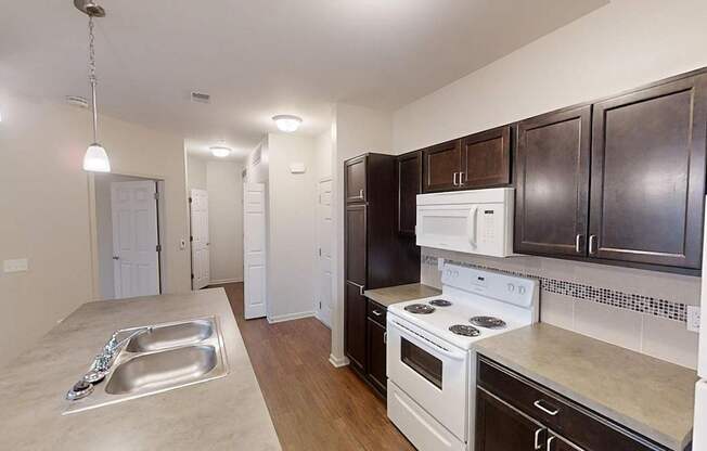 a kitchen with white appliances and dark wood cabinets