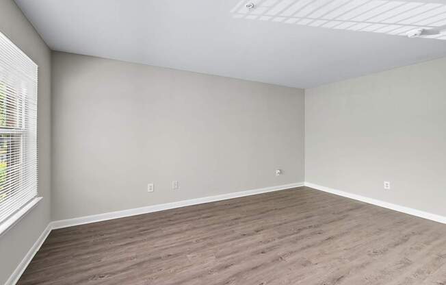 A room with wooden flooring and white walls.
