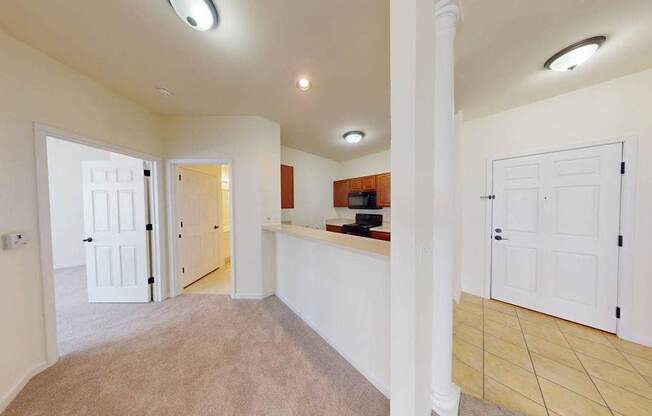 A spacious room with white walls and a carpeted floor.
