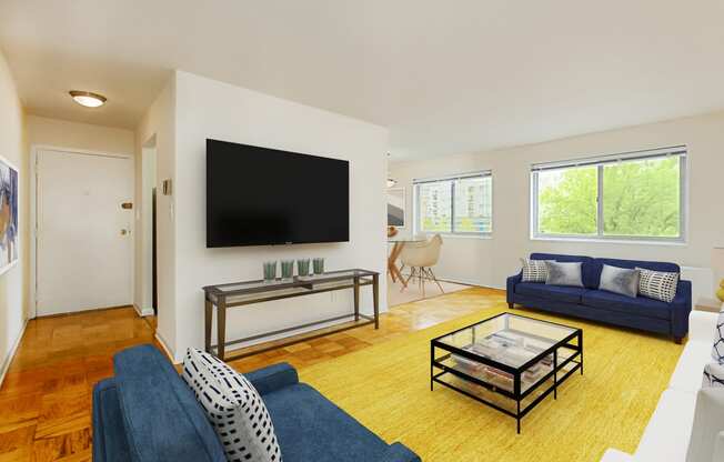 living area with wood flooring, sofa, love seat, coffee table, tv and large windows at chillum place apartments in washington dc