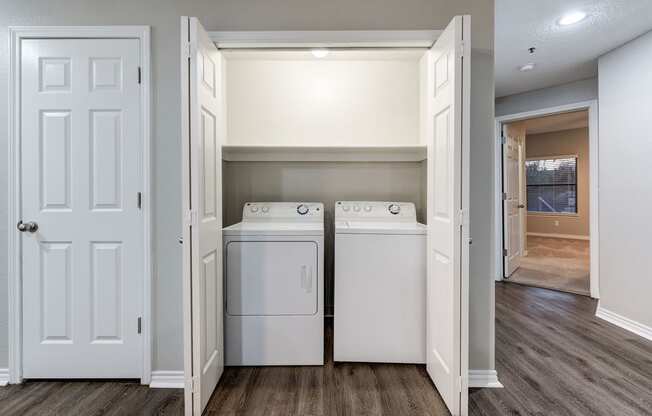 an empty laundry room with two washes and a dryer at Ashford Belmar Apartments, Lakewood, CO