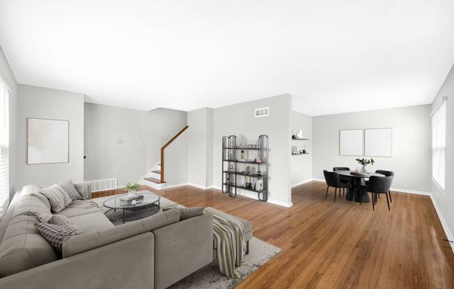 a living room with a gray couch and a dining room table