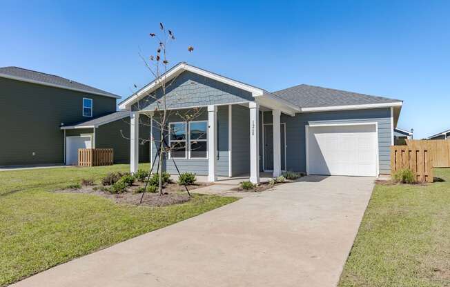 a blue house with a driveway and a white garage door