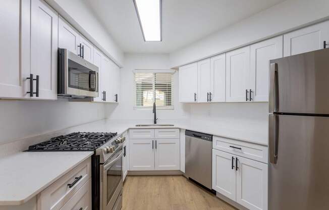 A kitchen with white cabinets and a black stove top.