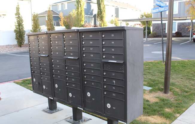 a bunch of mailboxes are on a sidewalk in front of a building