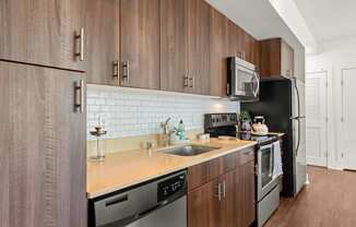 A kitchen with wooden cabinets and black appliances.