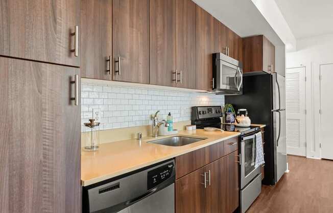 A kitchen with wooden cabinets and black appliances.