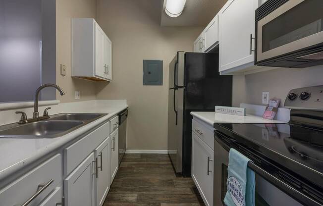 a kitchen with white cabinets and black appliances