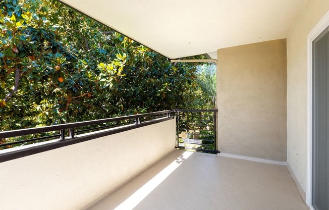 a large balcony with a tree next to a house