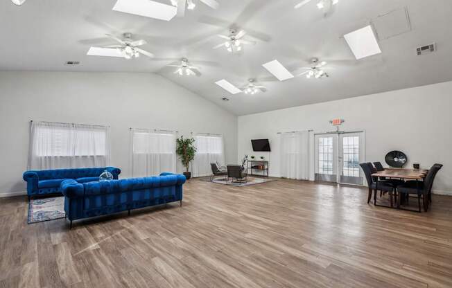 A living room with a blue couch and wooden floors.