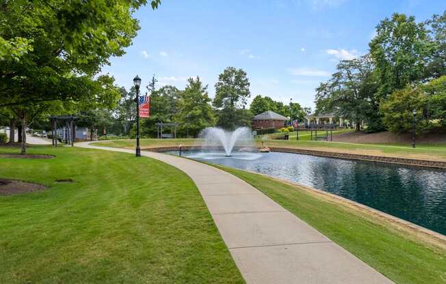 A park with a fountain and a flag.