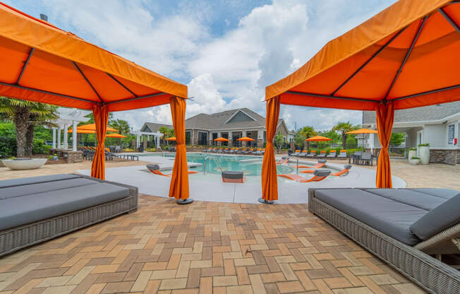 our apartments have a pool and cabanas with orange umbrellas
