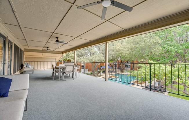 a large covered porch with a pool and a table and chairs