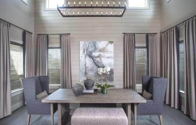 a dining room with a table and chairs and a painting on the wall