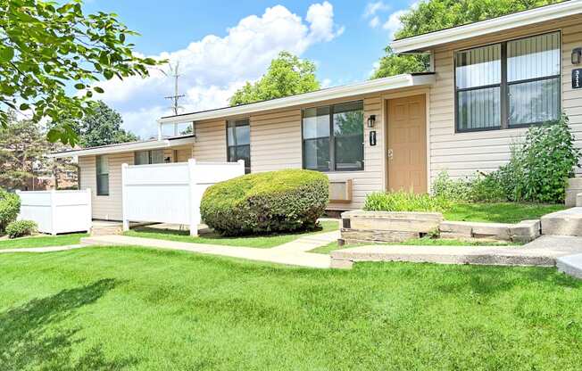 A house with a white fence and green lawn.
