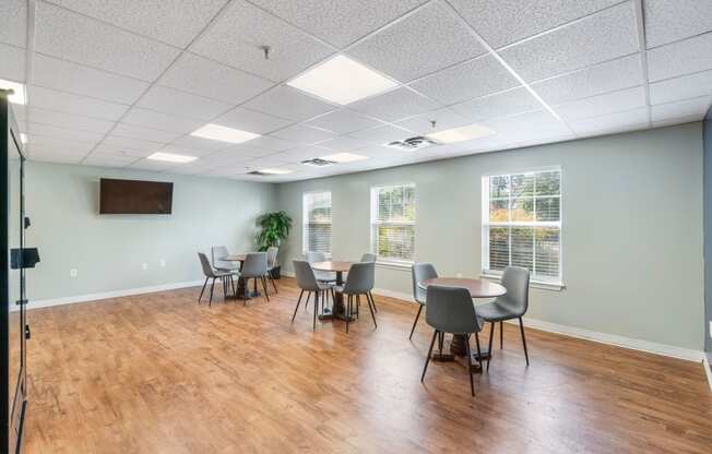 a conference room with tables and chairs and a wall mounted tv