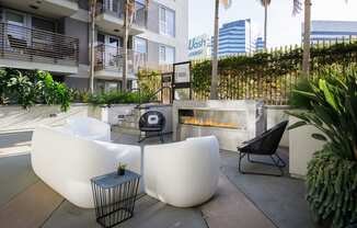 a seating area with a fire pit and chairs in front of a building