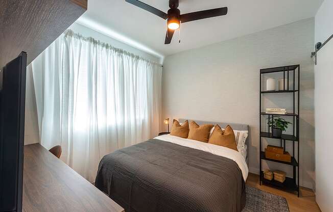 a bedroom with a bed and a ceiling fan