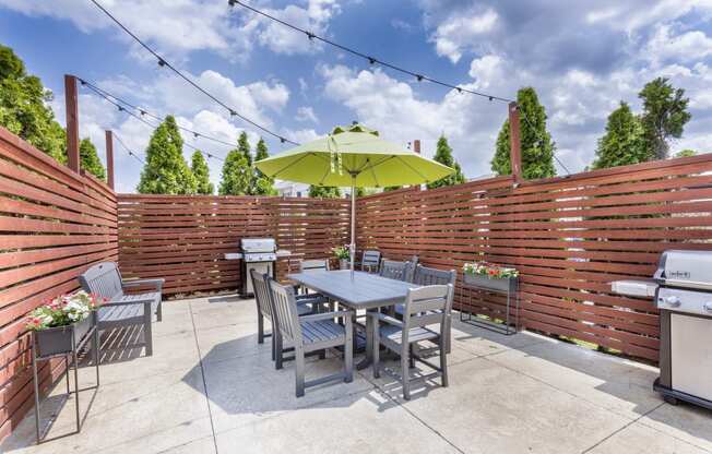 a patio with a table and chairs and an umbrella