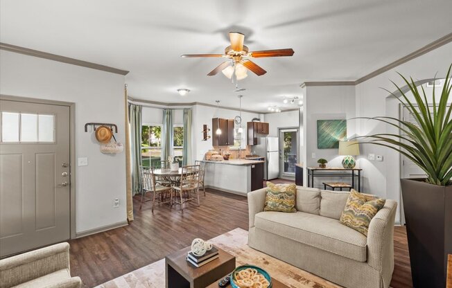 a living room with a couch a table and a ceiling fan