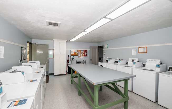 a room with a table and washing machines