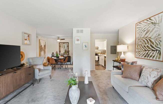 A living room with a grey couch and a wooden entertainment unit.