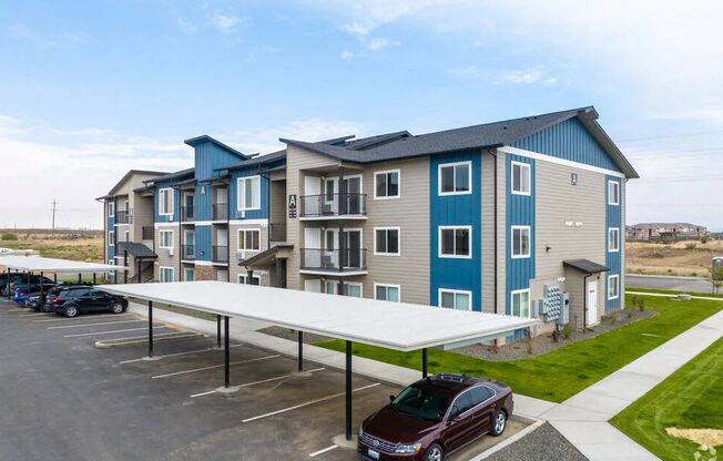 an apartment building with a car parked in a parking lot