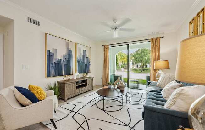a living room with a couch and chairs and a ceiling fan
