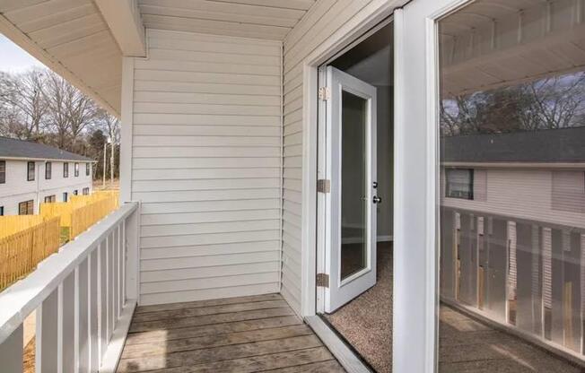 a balcony with a door to a white house at Cleo Apartments, Athens, AL