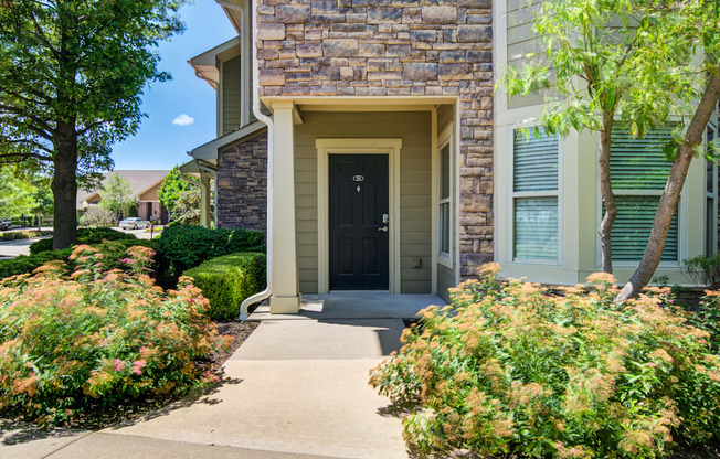 A house with a black door and a stone wall.