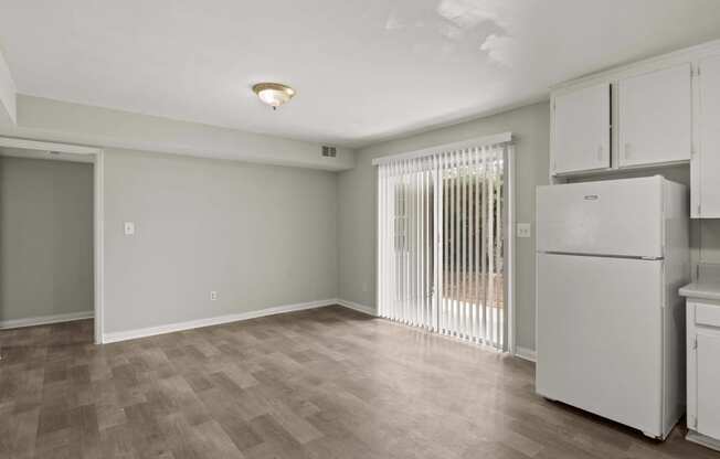 a kitchen and living room with white appliances and a sliding glass door