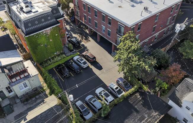 an aerial view of a city street with cars parked in a parking lot