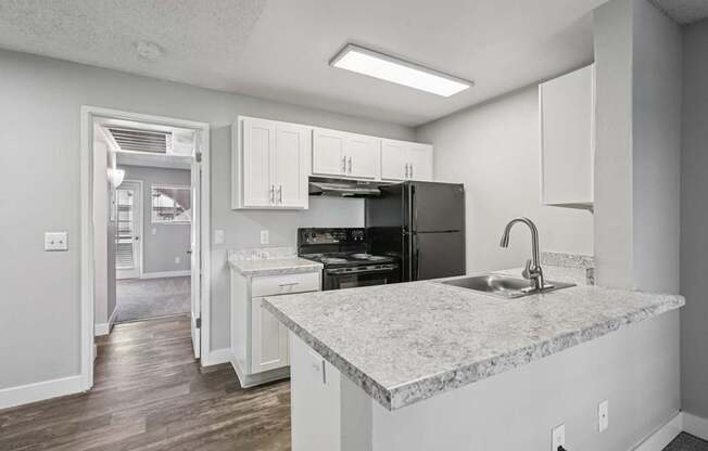 Model kitchen with a marble countertop and white cabinets.