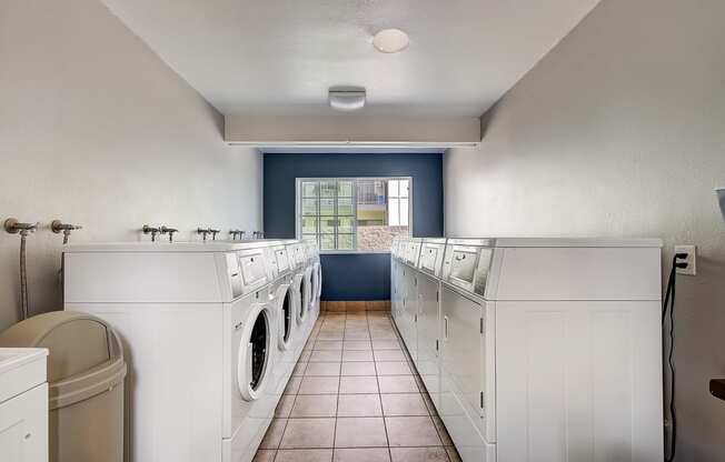 a laundry room with white washers and dryers