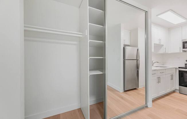 A kitchen with a refrigerator, sink, and cabinets.