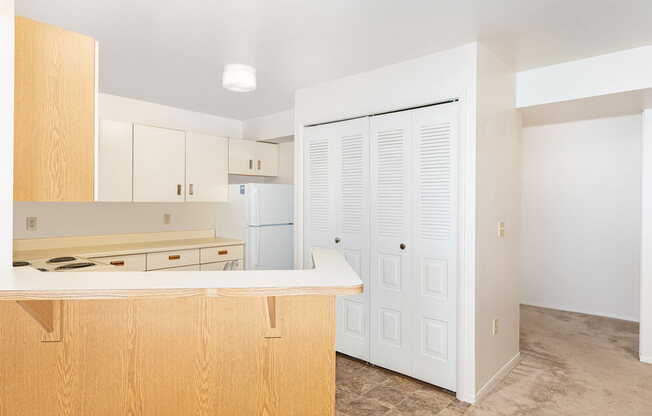 A kitchen with wooden cabinets and a white fridge at Oak Shores Apartments in Oak Creek, WI