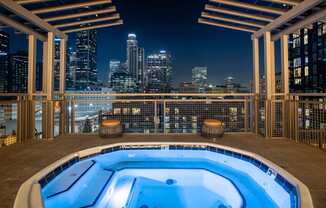 a rooftop spa with a view of the city at night
