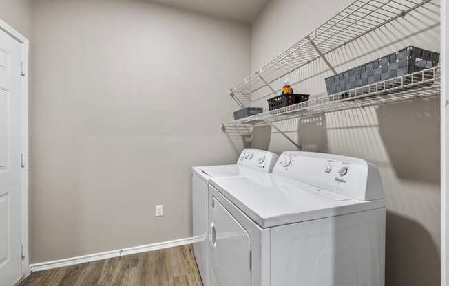 the laundry room of a home with a washer and dryer and a rack