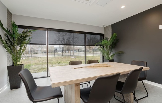 a dining room with a table and chairs in front of a window