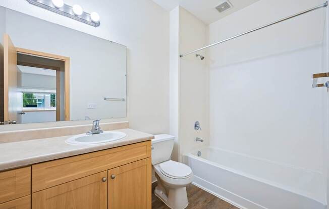 Soho bathroom with a vanity sink, toilet, and bathtub at Abbey Rowe Apartments in Olympia, WA