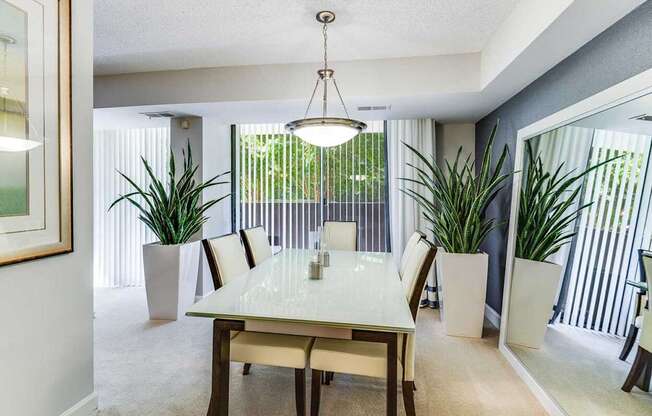 A dining room with a table and chairs.