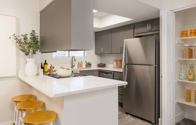 a kitchen with gray cabinets and a white counter top