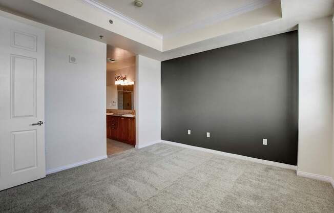 A room with a white door and a carpeted floor.