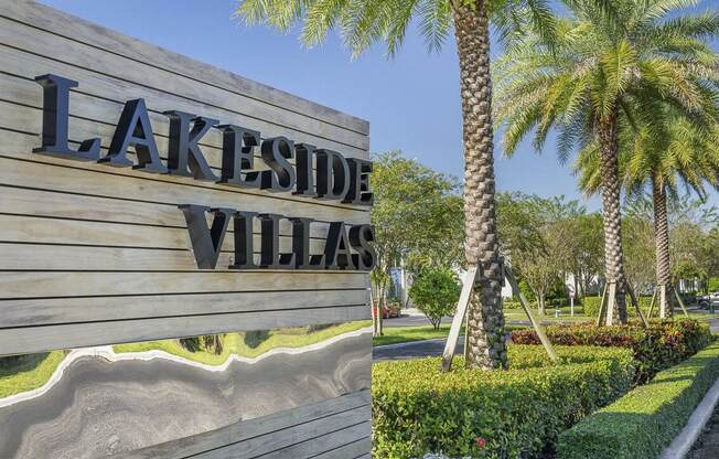 a sign for the lakeside villas at lakeside village with palm trees at Lakeside Villas, Florida