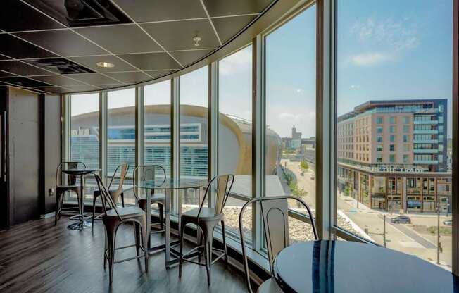 A room with a table and chairs with a view of the city.