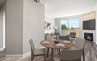 Hardwood floored dining room with view of balcony and stone walled fireplace.